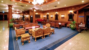 Un vestíbulo amplio con mobiliario de madera, candelabros y una alfombra azul.