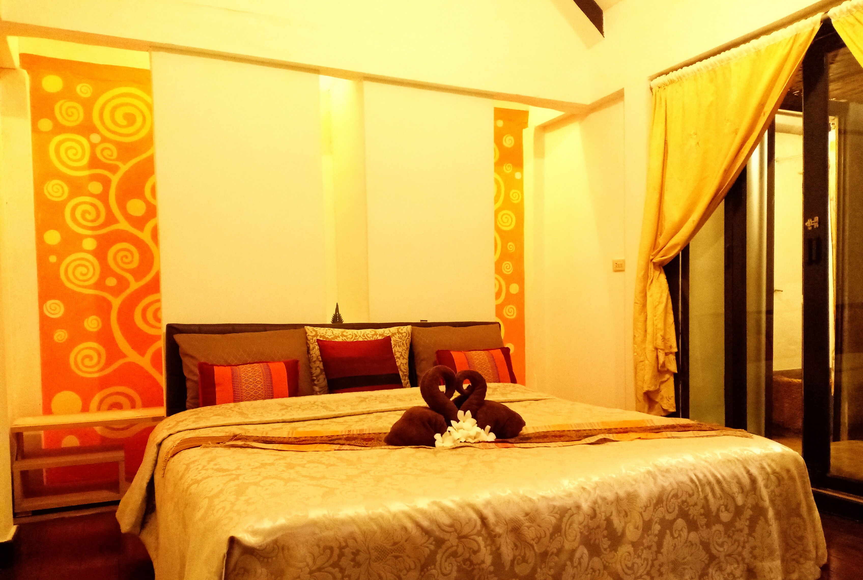 Une chambre d’hôtel avec un lit, des oreillers et un rideau.