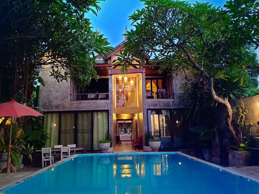 Um edifício de dois andares com piscina em frente.