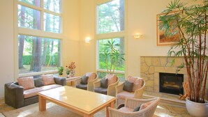 A spacious living room with large windows, a fireplace, and comfortable seating. - Hatago SAKURAYA (Yamanakako)