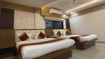 A modern hotel room with two beds, a large window, and an air conditioning unit.