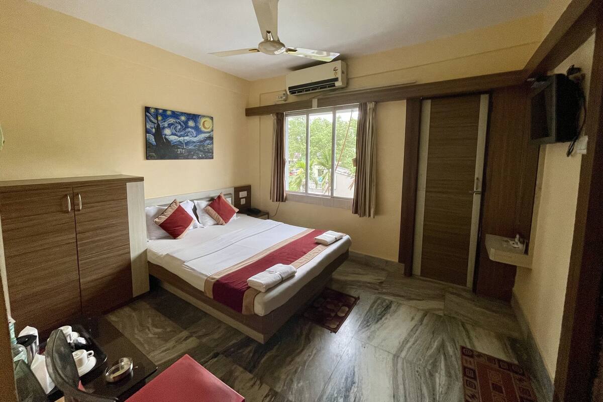 Una habitación de hotel con cama, armario y ventilador de techo.