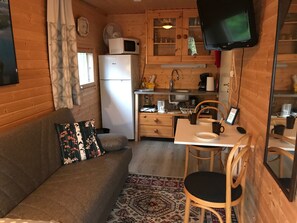 Cozy retreat with a sofa, dining table, and kitchenette, perfect for a relaxing stay.