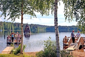 Guests can enjoy serene lakeside views from the dock, surrounded by lush greenery and a unique lake sculpture.