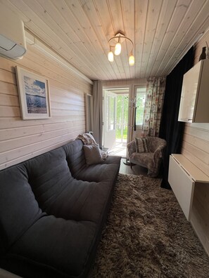 Relax in a cozy room with a sofa, patterned rug, and a framed picture on the wall.