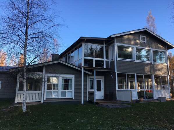 Stunning two-story home with a modern design, featuring a spacious porch and beautifully manicured lawn.