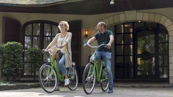 Couples can ride bicycles to the entrance of this charming building with arched windows.