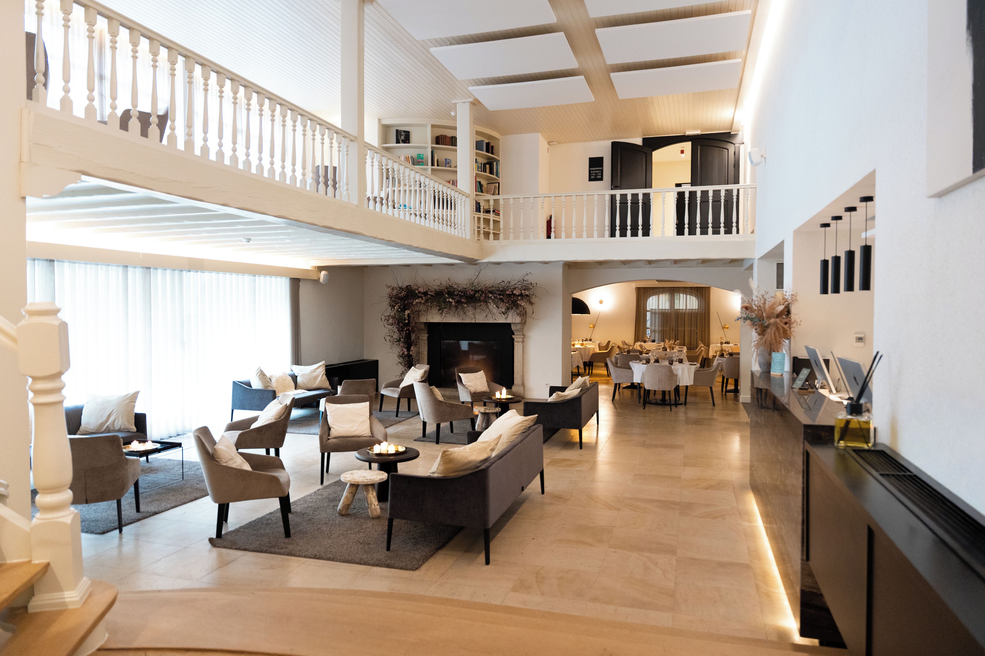 Uma sala de estar ampla com lareira, sofás e área de jantar.
