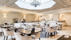 Un restaurante moderno con una barra central, varias mesas para comer y una pared con diseño.