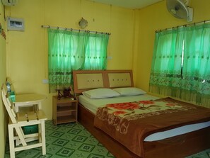 A room with a bed, a chair, a small table, and a fan. - Khunya Resort Riverkwai (Kanchanaburi)