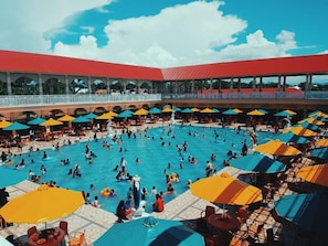 A large outdoor swimming pool with multiple umbrellas and lounge chairs. - Grand Town Hotel Mandai (Mandai)