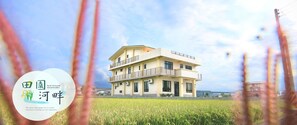A two-story building with a balcony, surrounded by a field. - Pastoral riverside (Dongshan)