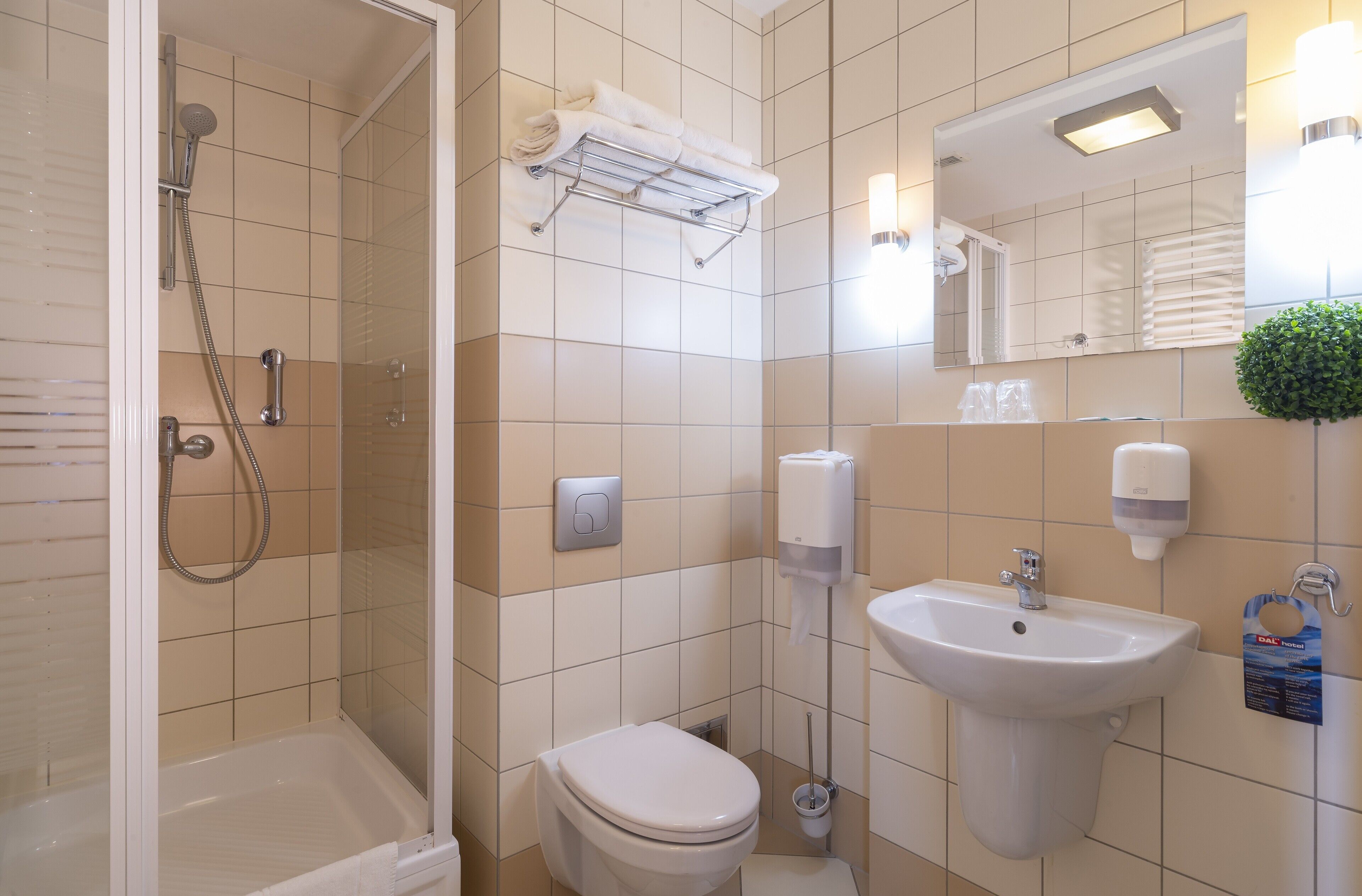 Une salle de bain moderne équipée d’une douche, de toilettes, d’un lavabo et d’un porte-serviettes.