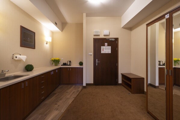 A hotel bathroom with a sink, mirror, towel dispenser, and a small plant. - Hotel Dal Kielce (Kielce)