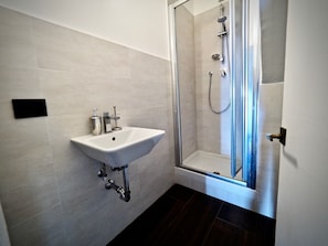Appartement | Badkamer | Een douche, gratis toiletartikelen, een haardroger, handdoeken