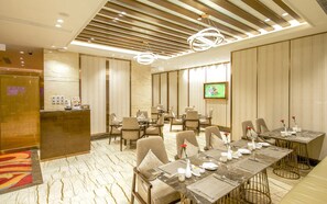 A conference room with a long table set for dining, equipped with chairs, a television screen, and a reception desk. - Royal Dragon Hotel (Macau)