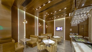 A modern restaurant with wooden paneling, striped cushioned seating, and hanging wine glasses. - Royal Dragon Hotel (Macau)
