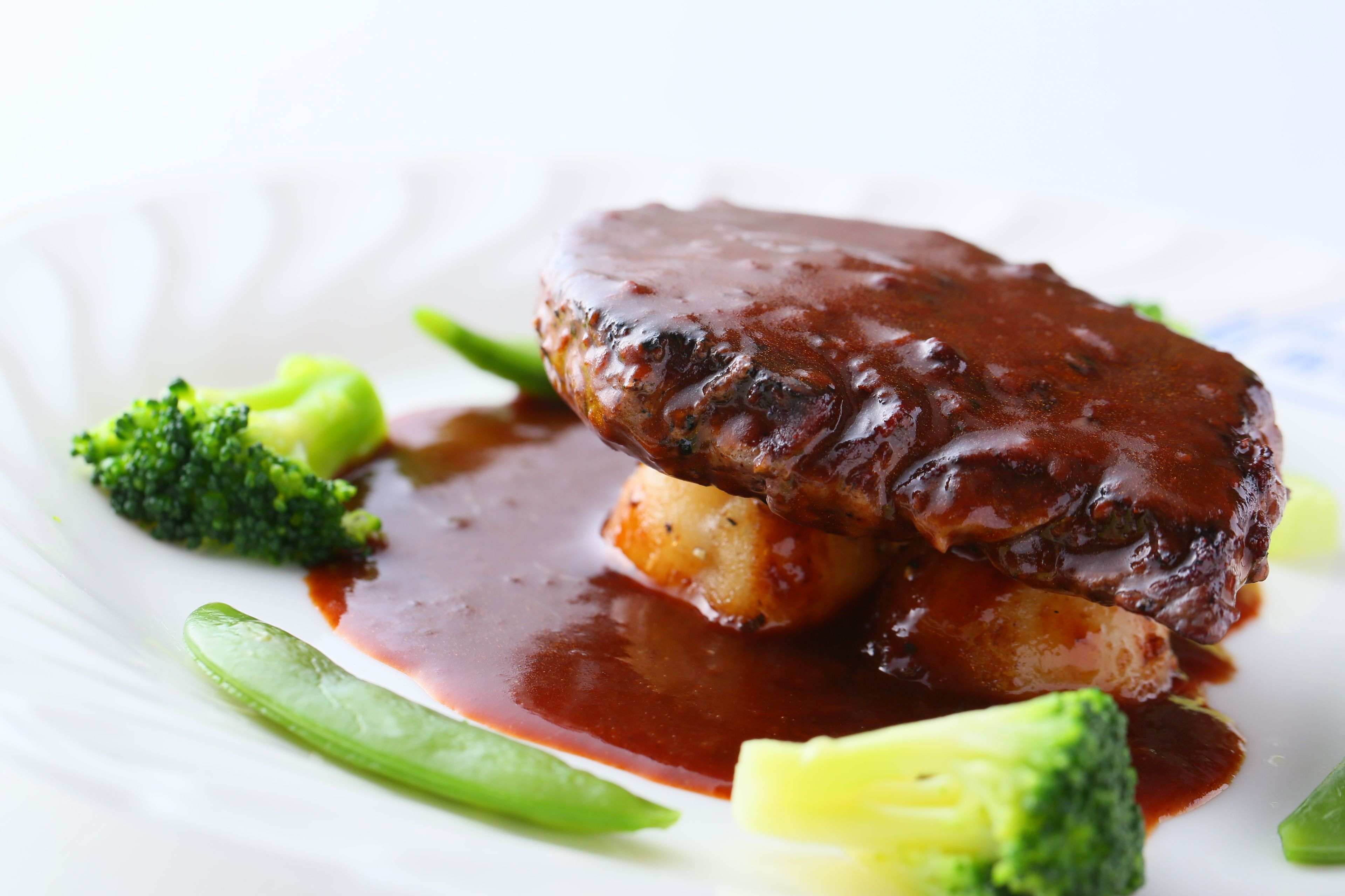 A plate with a meat dish, vegetables, and sauce.