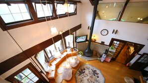A spacious loft with high ceilings, large windows, and a fireplace. - Chalet La Neige (Minakami)