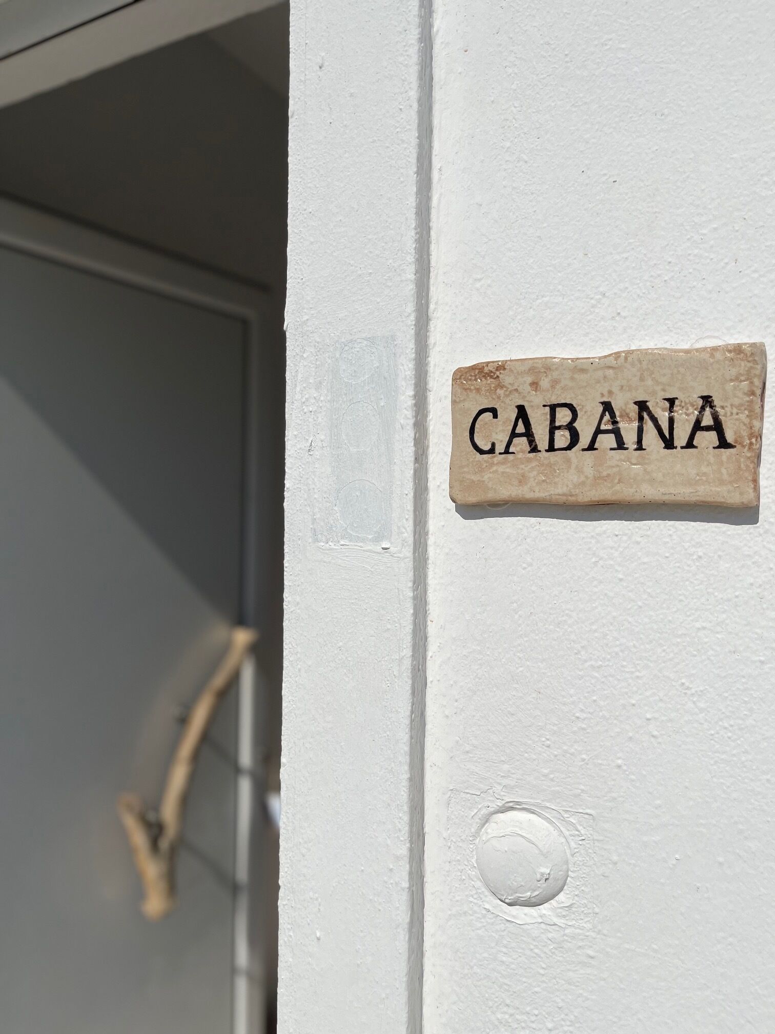 Una puerta blanca con un letrero que dice 'CABANA'.