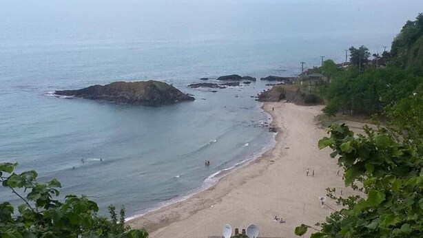 Ein Strand mit Felsen und einem Sandufer.