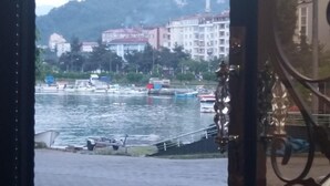 Blick auf einen Fluss mit Booten und Gebäuden im Hintergrund.
