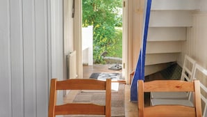 A wooden chair and a small table in a narrow hallway with a view of a garden and a staircase. - 1 bedroom cozy home in Jönköping (Jönköping)