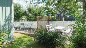 A backyard with a white fence, a wooden pergola, a table and chairs, and various plants. - 1 bedroom cozy home in Jönköping (Jönköping)