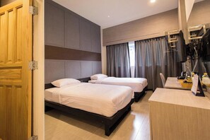 A hotel room with two beds, a desk, and a wardrobe. - Lazy Sunday Hostel (Bangkok)