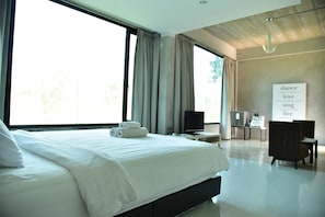 A modern hotel room with a large bed, a desk, and a TV. - Home Elements Khaoyai (Pak Chong)