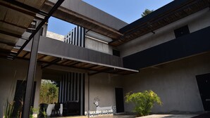 A modern building with a covered outdoor area, a dining setup, and a mural of a dog. - Home Elements Khaoyai (Pak Chong)