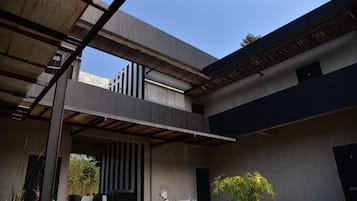 A modern building with a covered outdoor area, a dining setup, and a mural of a dog.