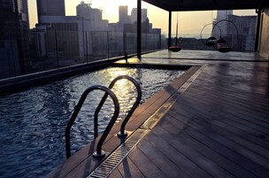 Una piscina al aire libre, sillones reclinables de piscina