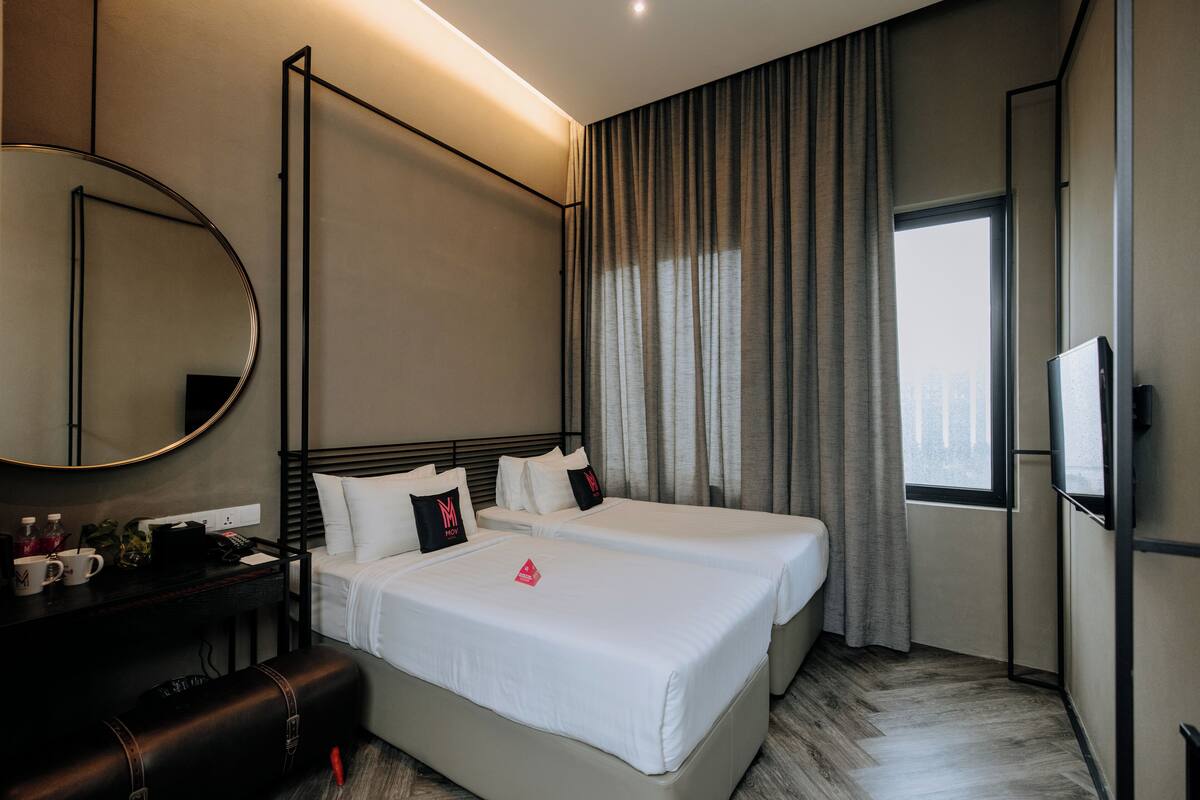 Een hotelkamer met een groot bed, een bureau met spiegel en een televisie.