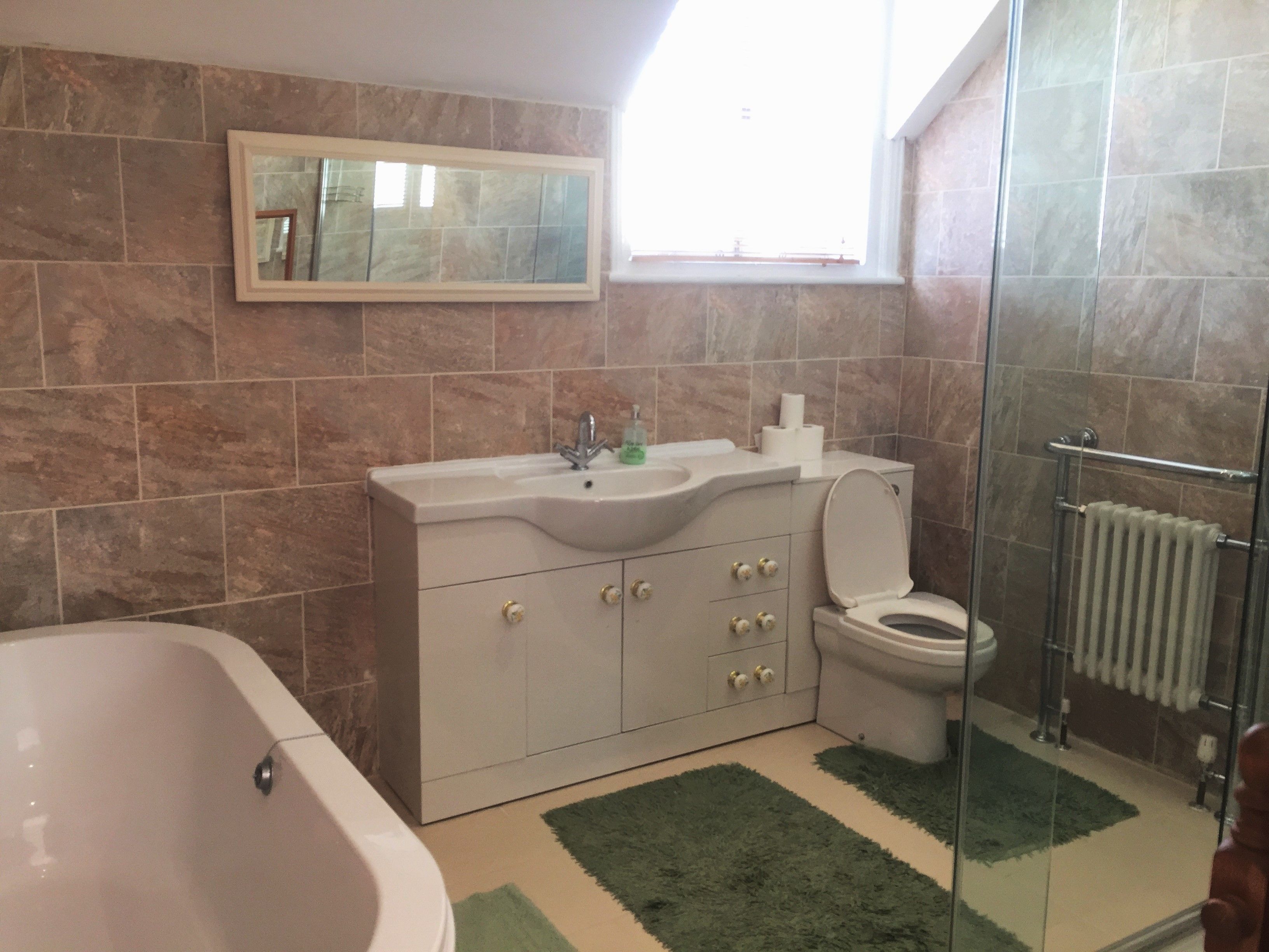 Un baño con bañera, lavabo, inodoro y cabina de ducha de vidrio.