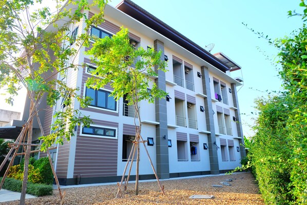 A multi-story building with a modern architectural design, featuring balconies and large windows. - Nai-Ya-Place (Kanchanaburi)