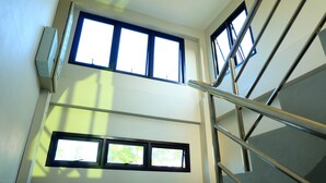 A multi-level interior with staircases and windows allowing natural light. - Nai-Ya-Place (Kanchanaburi)