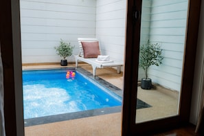 A small indoor pool with a white lounge chair and two potted plants. - The Vintage Hotel Khaoyai (Pak Chong)