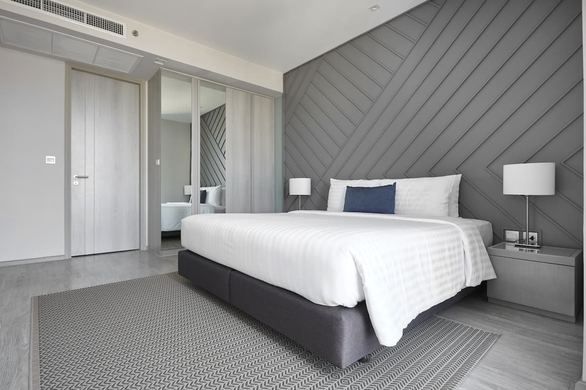 Ein modernes Schlafzimmer mit einem großen Bett, Nachttischen und einem Kleiderschrank.