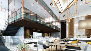 Un interior moderno con comedor, cocina y un puente de cristal hacia un nivel superior.
