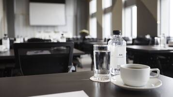 A dining table with a water bottle, a glass, and a cup of coffee in a modern restaurant setting.
