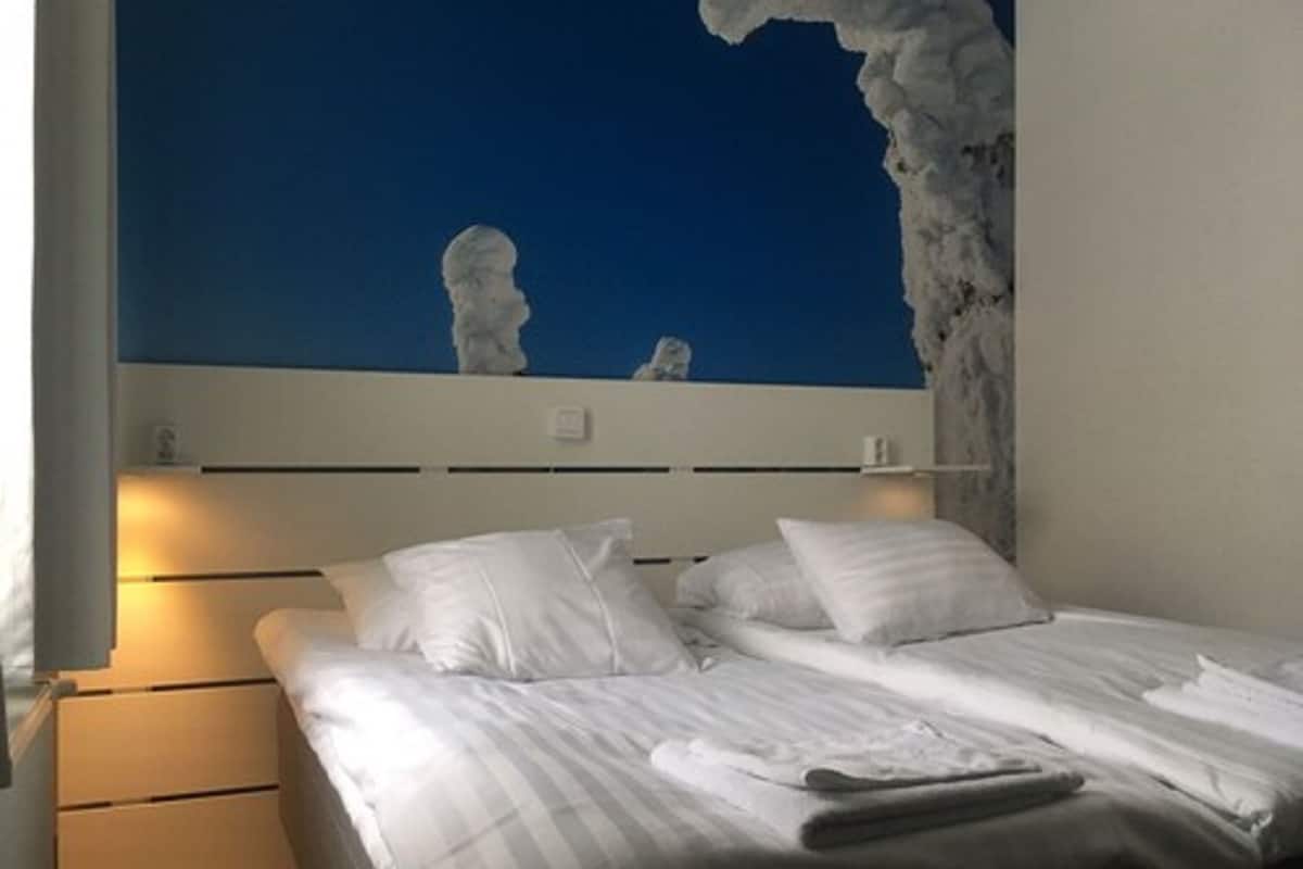 A bedroom with a bed, pillows, and a nightstand.