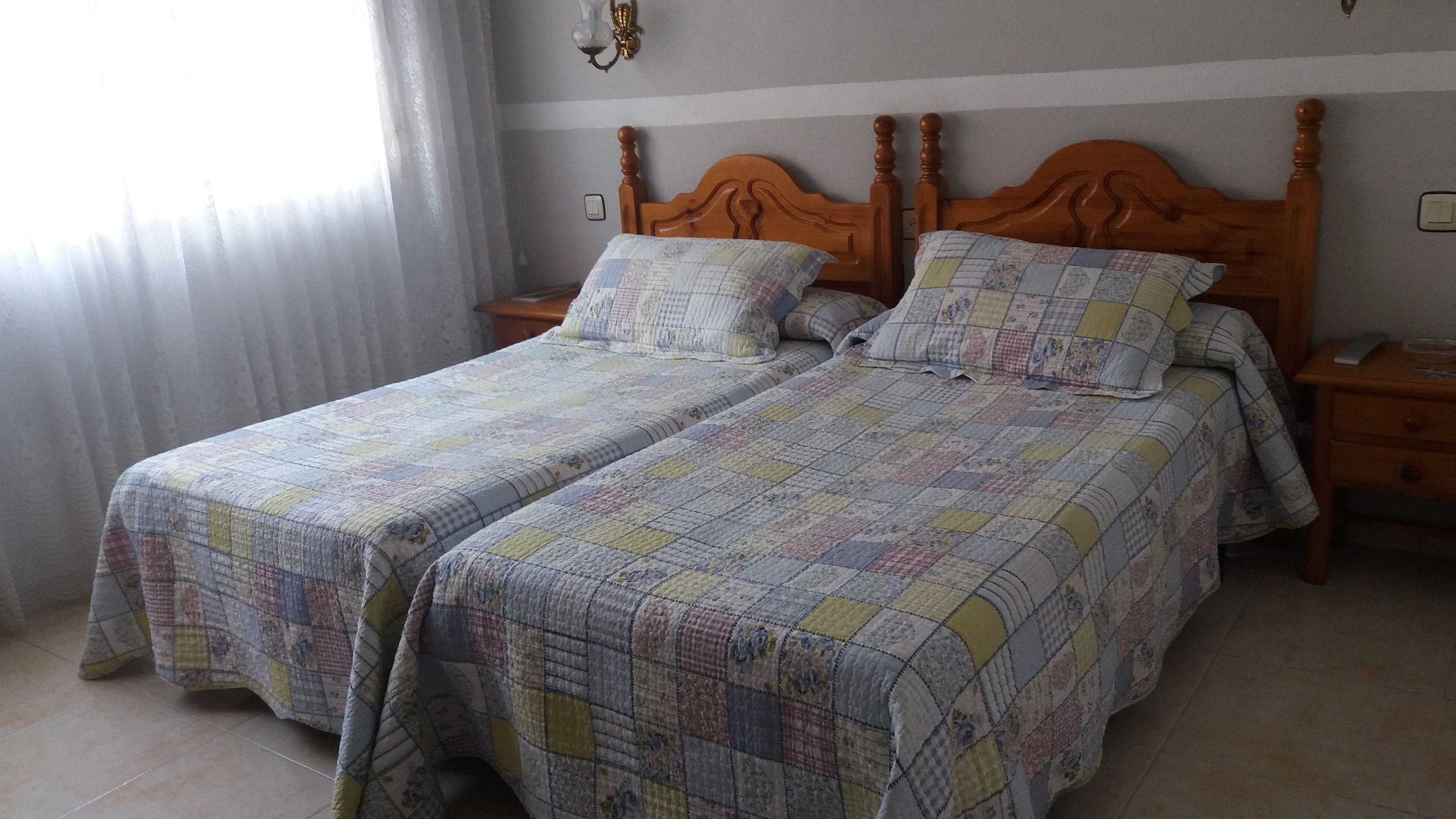 A double bed with a wooden headboard and two bedside tables.