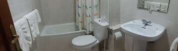 Un baño con bañera, inodoro y lavamanos.