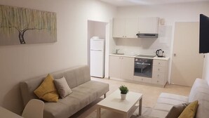 Un salon moderne avec un canapé, une table basse et un téléviseur.