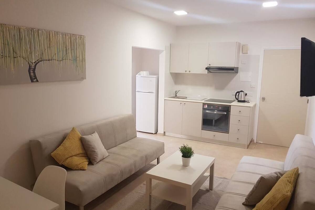 Un salon moderne avec un canapé, une table basse et un téléviseur.