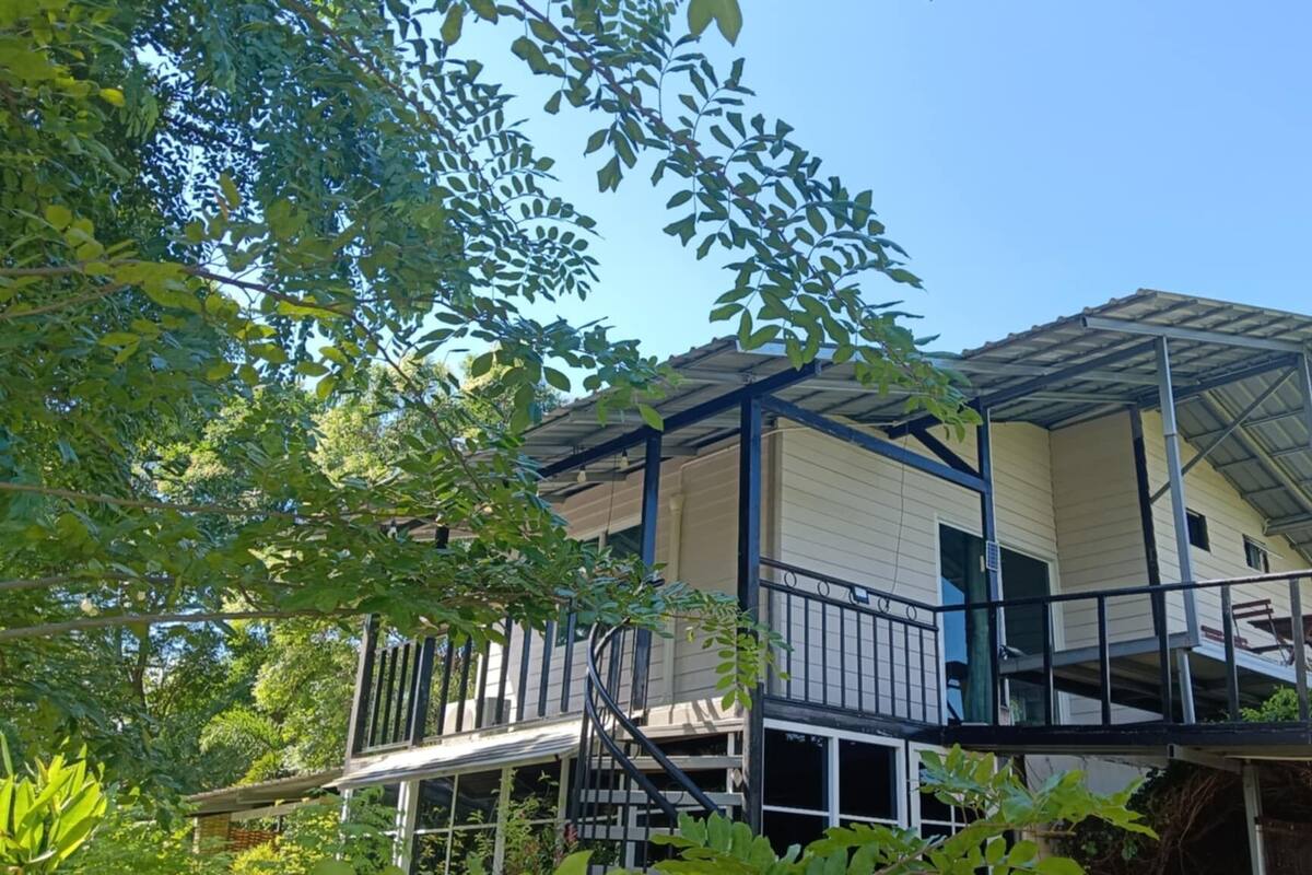 A two-story building with a metal roof and a balcony.