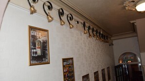 A wall with a series of bells and posters, including one for a comedy show. - The White Hart Hotel (Holsworthy)