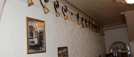 A wall with a series of bells and posters, including one for a comedy show.