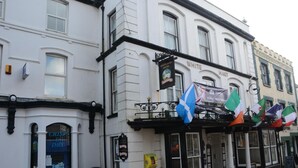 A building with a sign for 'White Hart Hotel' and a 'CRISP & DRY' shop. - The White Hart Hotel (Holsworthy)